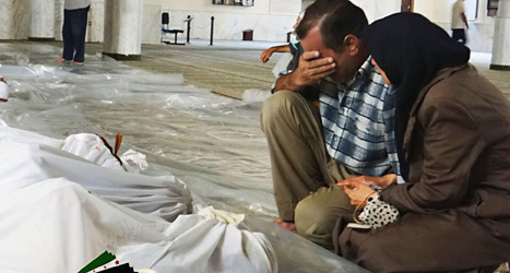 En man och en kvinna sörjer vid de döda kropparna i al-Ghuta. Foto: AP/Scanpix